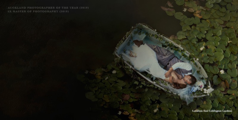Bride and groom lying in a boat among lily pads, aerial wedding photograph