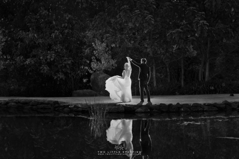 Bride and groom dancing by the water, black and white wedding photograph